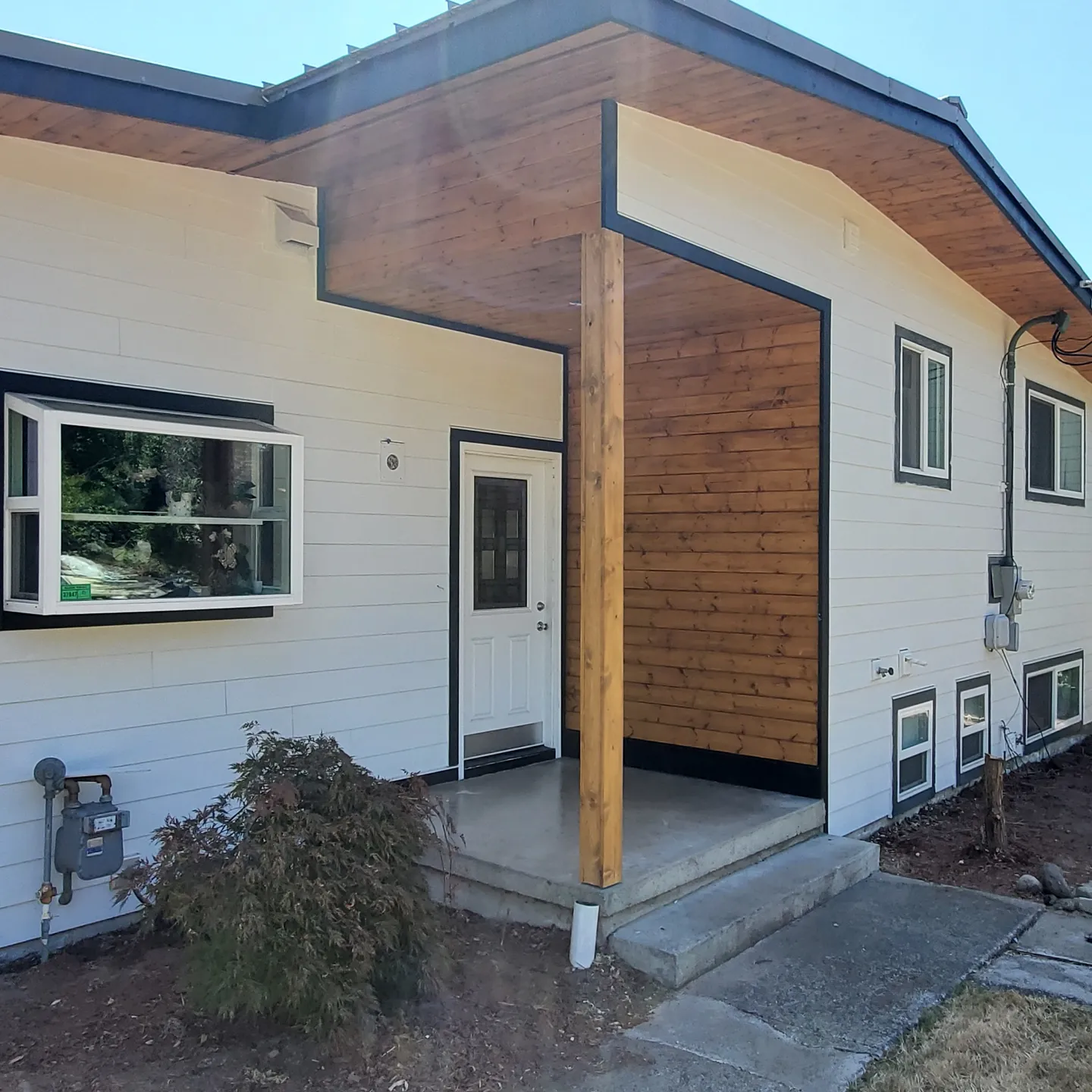 Residential siding with covered entry and wood accent detail by Breeze Siding