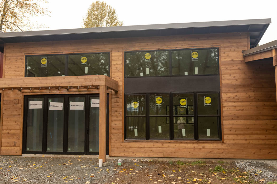 Single-story cedar exterior with large black windows